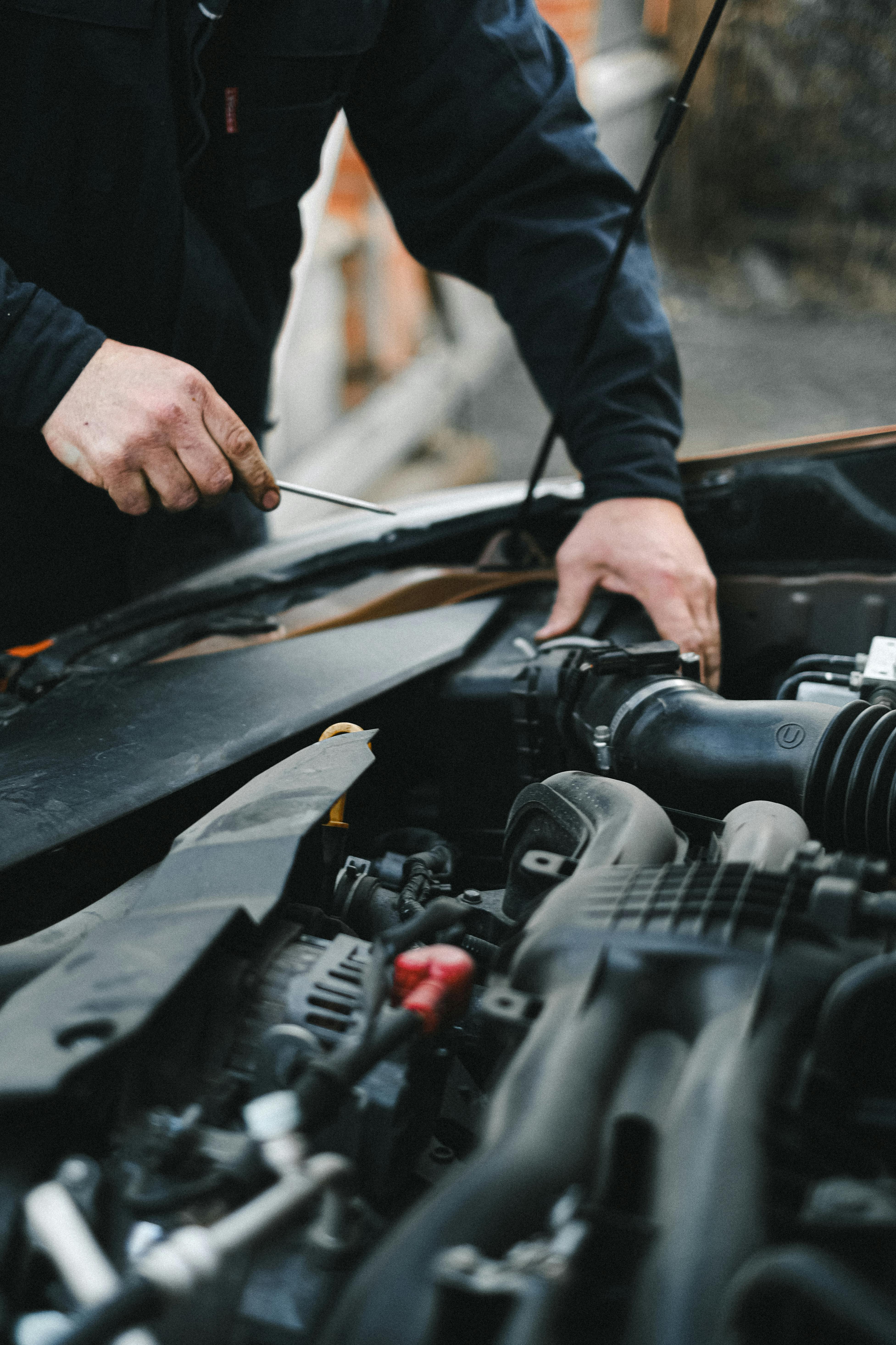 Hands under the bonnet carrying out initial engine-bay electrical checks.